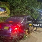 Image showing a Toyota Mark X after crashing into a ditch on Magentaweg in Suriname. The car is back on the road, with police investigating the incident.