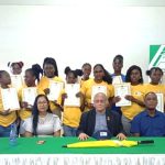Lekeijcia Adams ontvangt de laptop van minister Steven Mac Andrew.
