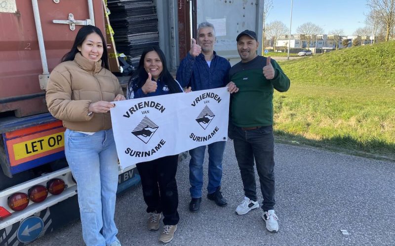 Vluchtelingen in Nederland dragen bij aan het laden van hulpcontainer voor Suriname.