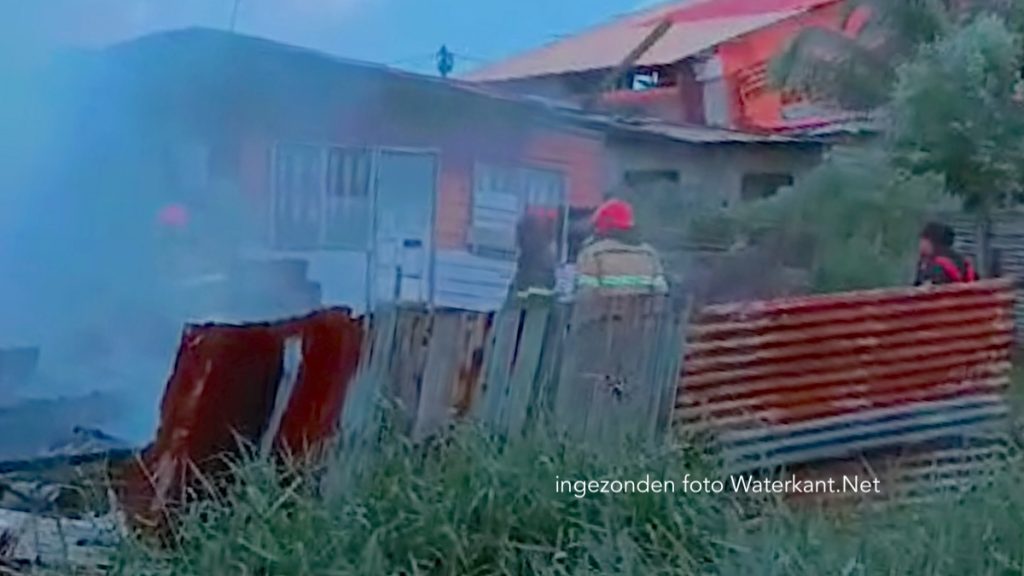 Brandweermensen van de Surinaamse brandweer verrichten bluswerkzaamheden.