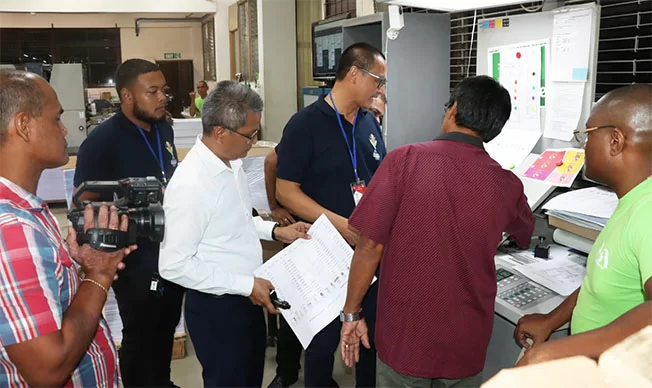Stembiljetten worden gevouwen voor de ressortraadsverkiezingen in Suriname, fouten inmiddels gecorrigeerd.