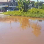 Grote waterplas op de hoek van de Surimomboweg en Coesewijnestraat na regenval in Suriname