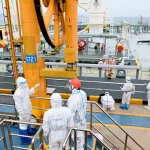 Immigratie-inspecteurs controleren een tanker in de haven van Qingdao.